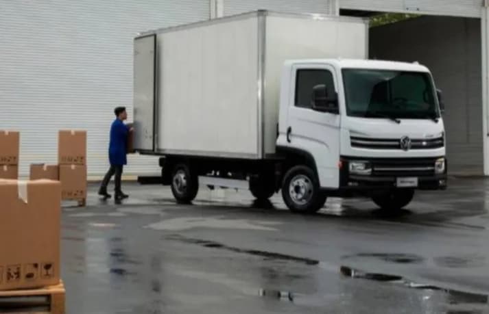 Caminhão branco em operação próximo ao galpão